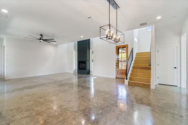 unfurnished living room featuring concrete floors and ceiling fan with notable chandelier