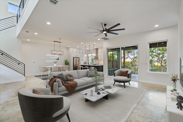 living room with ceiling fan with notable chandelier