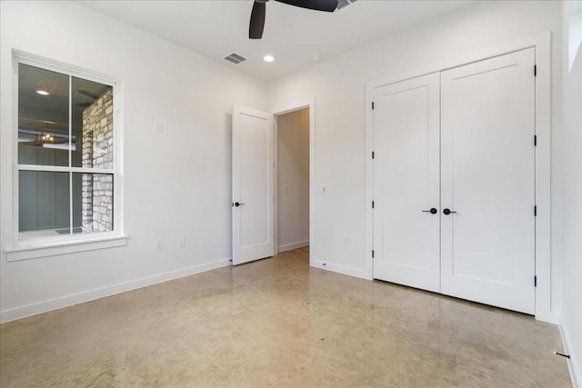 unfurnished bedroom with finished concrete flooring, recessed lighting, baseboards, visible vents, and a closet