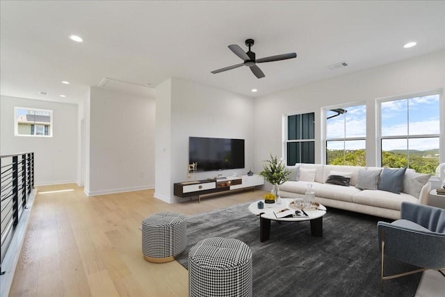 living room with light wood-type flooring, recessed lighting, and visible vents