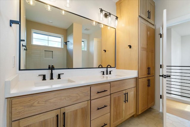 full bath featuring double vanity, a sink, tile patterned flooring, and tiled shower