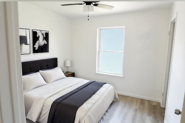 bedroom featuring multiple windows, light hardwood / wood-style flooring, and ceiling fan