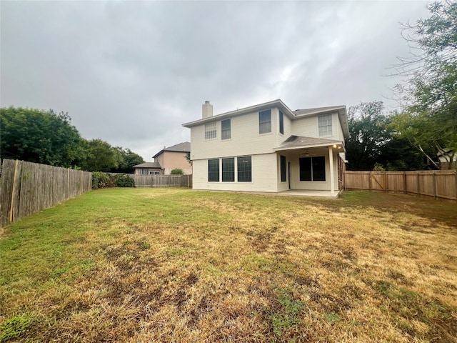 rear view of house featuring a yard and a patio