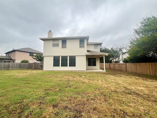 back of property featuring a lawn and a patio area