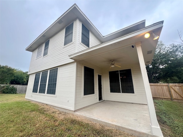 rear view of property featuring a patio, ceiling fan, and a lawn