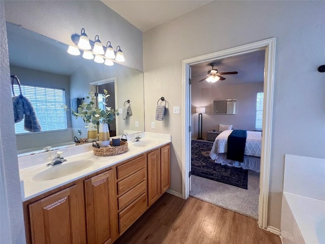 bathroom with hardwood / wood-style floors, ceiling fan, a bathing tub, and vanity