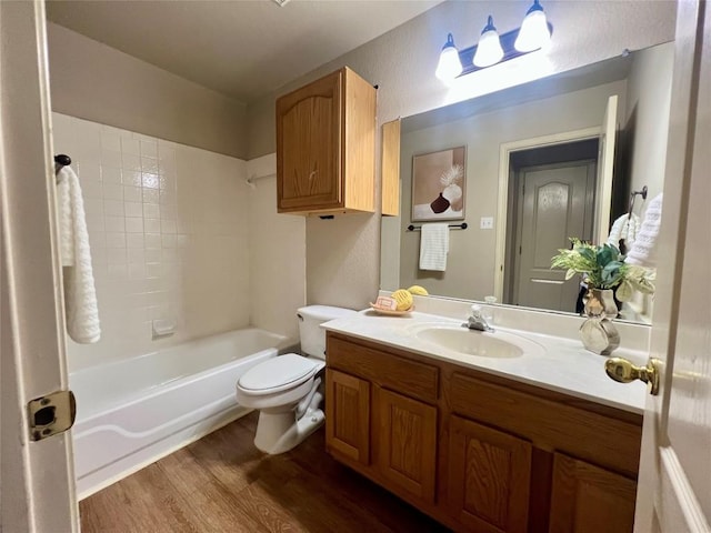 full bathroom with hardwood / wood-style floors, vanity, toilet, and washtub / shower combination