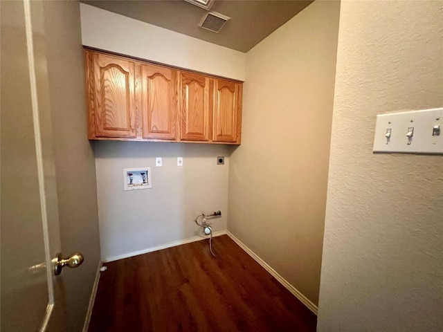 laundry area featuring gas dryer hookup, cabinets, dark wood-type flooring, washer hookup, and hookup for an electric dryer