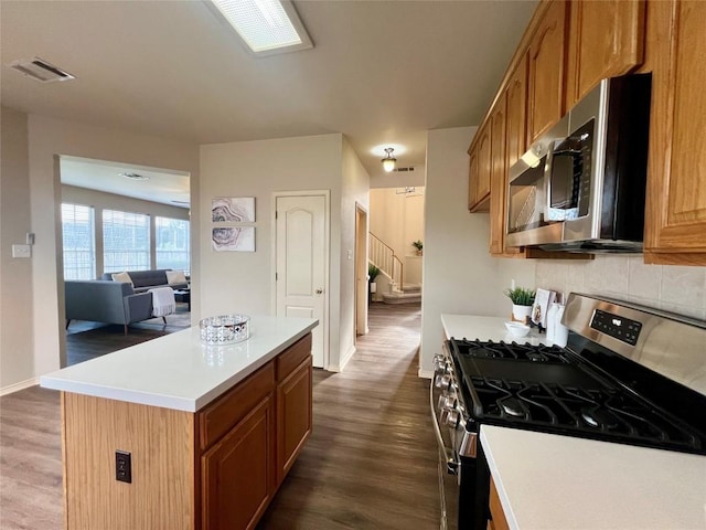 kitchen featuring a center island, stainless steel appliances, and dark hardwood / wood-style floors