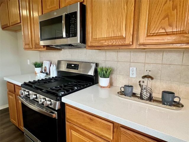 kitchen with decorative backsplash, stainless steel appliances, and dark hardwood / wood-style floors