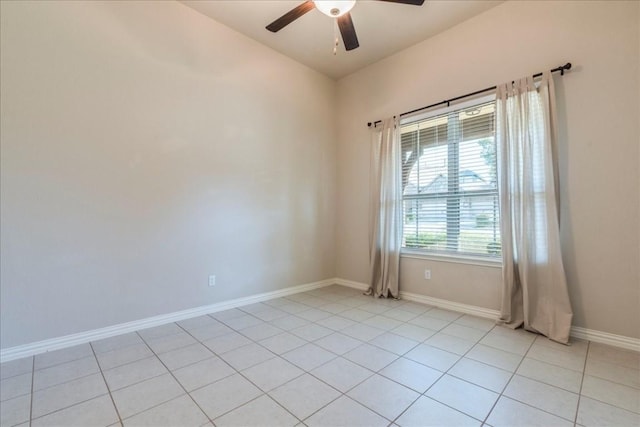 empty room featuring light tile patterned floors, ceiling fan, and baseboards