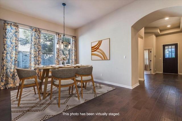 dining room with arched walkways, dark wood finished floors, baseboards, and recessed lighting