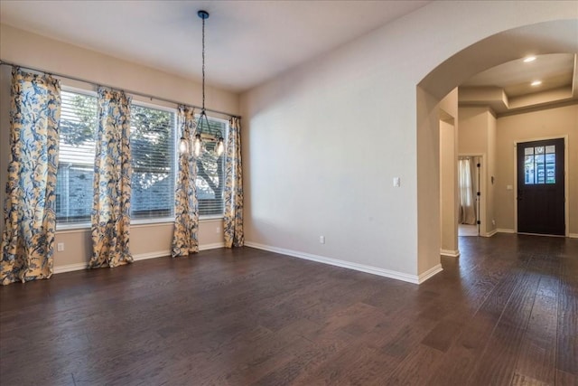 unfurnished dining area with dark wood-style floors, baseboards, arched walkways, and recessed lighting