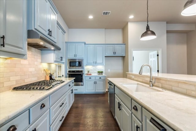 kitchen with stainless steel appliances, visible vents, dark wood-type flooring, a sink, and under cabinet range hood