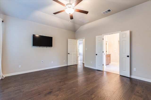 unfurnished bedroom featuring baseboards, visible vents, vaulted ceiling, and wood finished floors