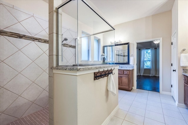 full bath with tile patterned floors, walk in shower, and vanity