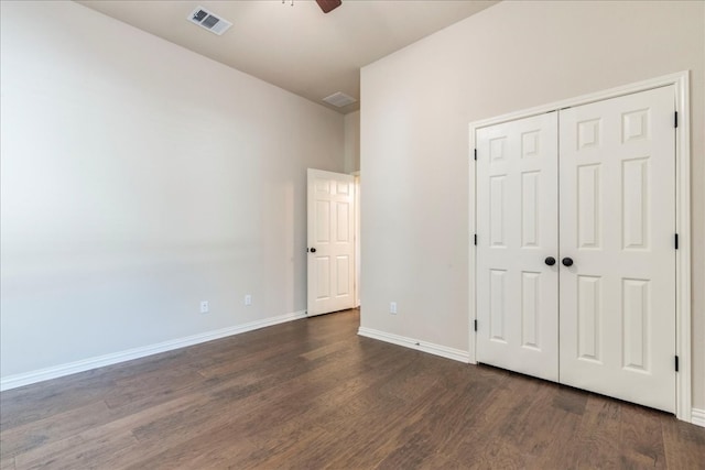 unfurnished bedroom with baseboards, visible vents, ceiling fan, wood finished floors, and a closet