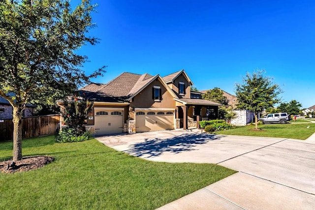 traditional-style house featuring a front yard, concrete driveway, fence, and an attached garage