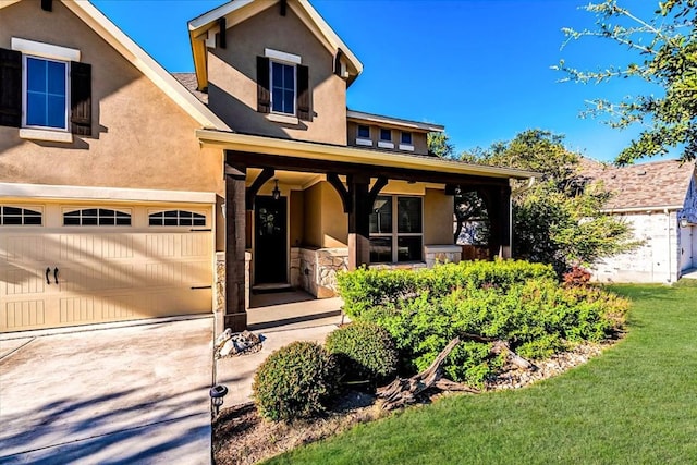 view of front of house featuring driveway, stone siding, a porch, and stucco siding