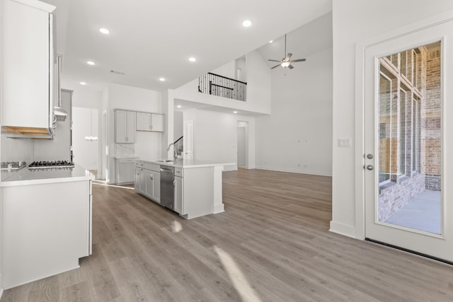 kitchen featuring white cabinetry, an island with sink, ceiling fan, stainless steel appliances, and light hardwood / wood-style floors