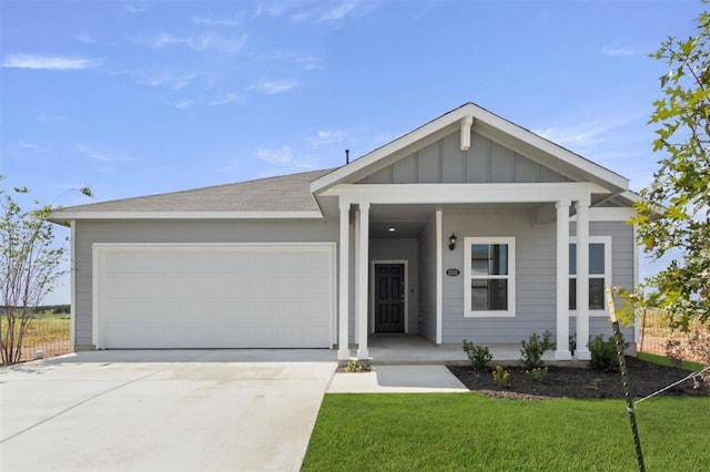 view of front of home with driveway, board and batten siding, an attached garage, and a front yard