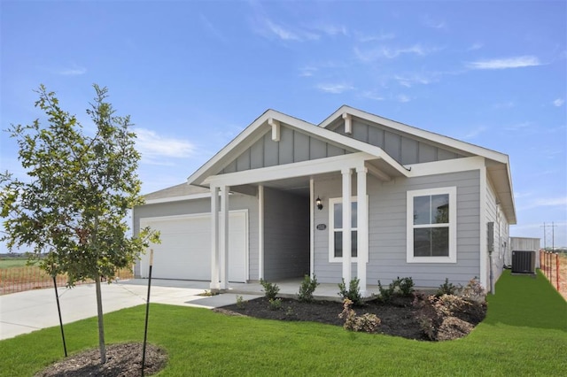 view of front of property with concrete driveway, covered porch, an attached garage, board and batten siding, and a front yard