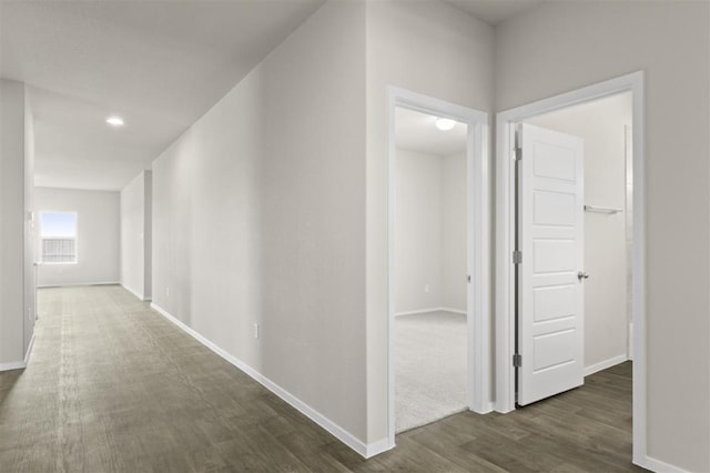 hallway with dark wood-style flooring and baseboards