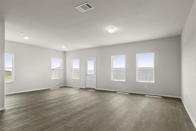 spare room with recessed lighting, dark wood finished floors, visible vents, and baseboards