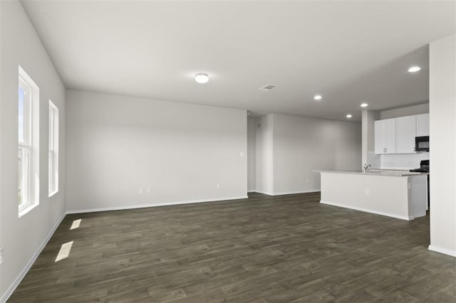 interior space featuring visible vents, baseboards, dark wood-style flooring, and recessed lighting