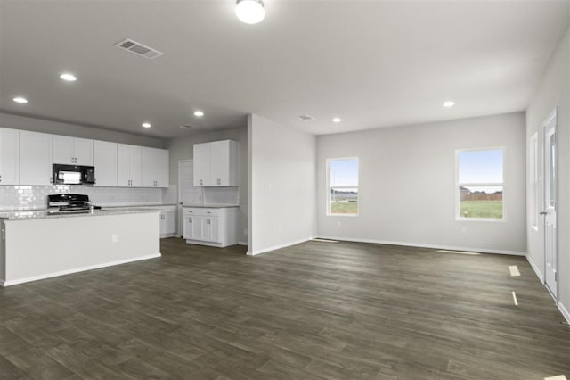 kitchen with plenty of natural light, visible vents, dark wood-style floors, stove, and black microwave