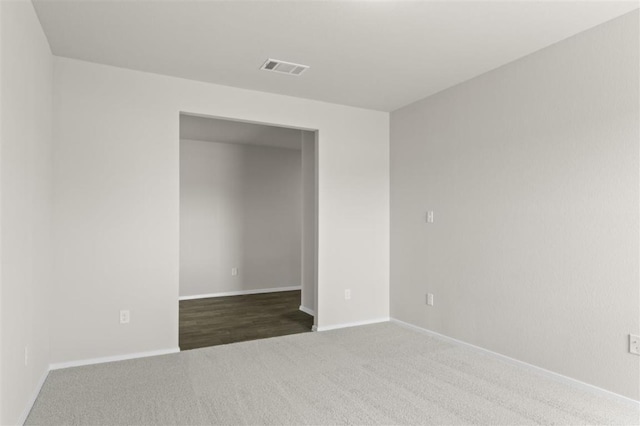 empty room featuring baseboards, visible vents, and carpet flooring