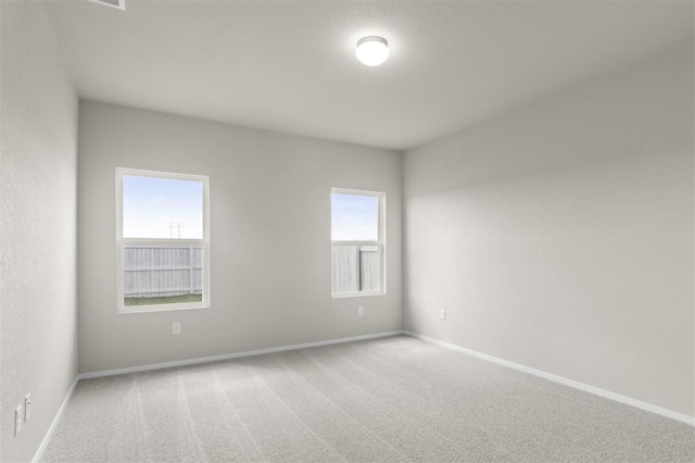 empty room with baseboards and carpet flooring