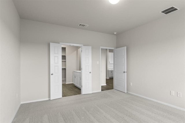 unfurnished bedroom featuring carpet, visible vents, and baseboards