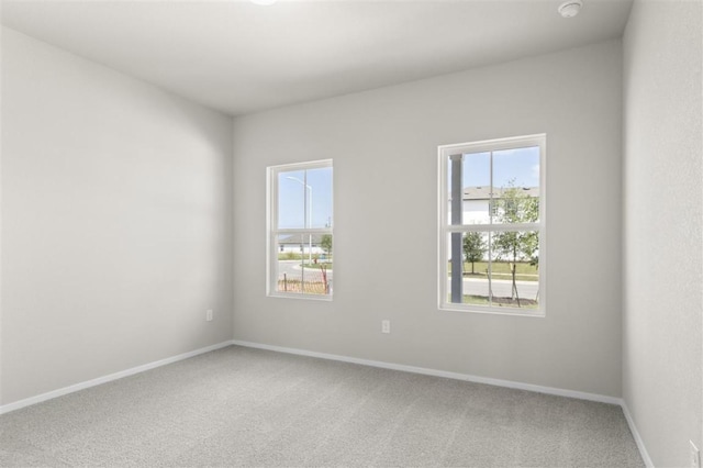 spare room featuring carpet floors and baseboards