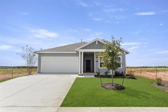 view of front of property with a garage, fence, concrete driveway, board and batten siding, and a front yard