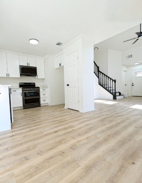 kitchen featuring ceiling fan, light hardwood / wood-style floors, appliances with stainless steel finishes, and white cabinetry