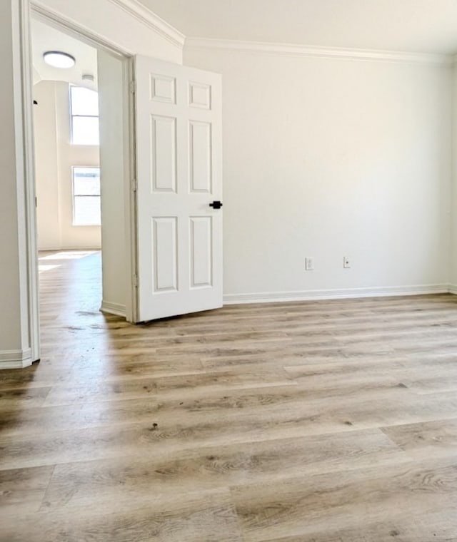 empty room featuring ornamental molding and light hardwood / wood-style floors