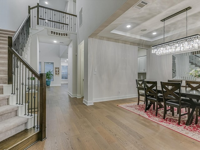 dining room with a raised ceiling and wood-type flooring