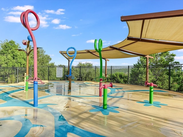 view of play area featuring a pool with hot tub