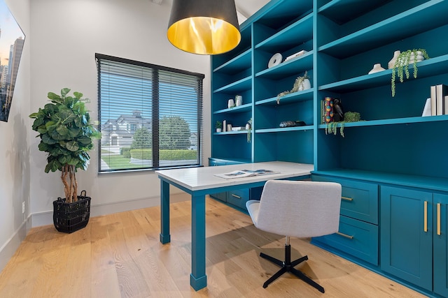 home office featuring built in features and light hardwood / wood-style floors