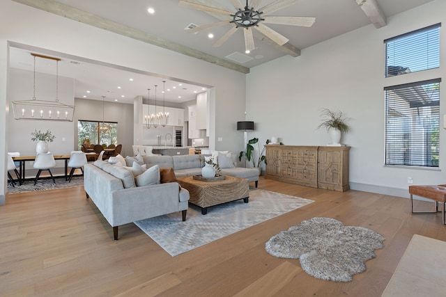 living room with sink, light wood-type flooring, beam ceiling, and a notable chandelier