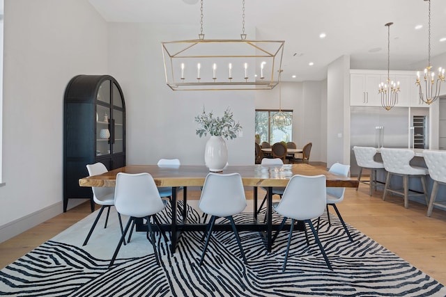 dining space featuring light hardwood / wood-style floors and a notable chandelier