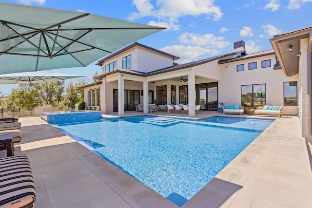 view of swimming pool with ceiling fan, an outdoor hangout area, and a patio