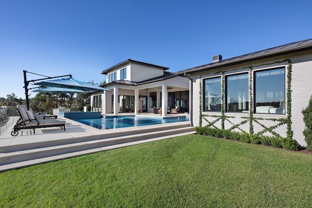 rear view of property featuring a patio area and a lawn