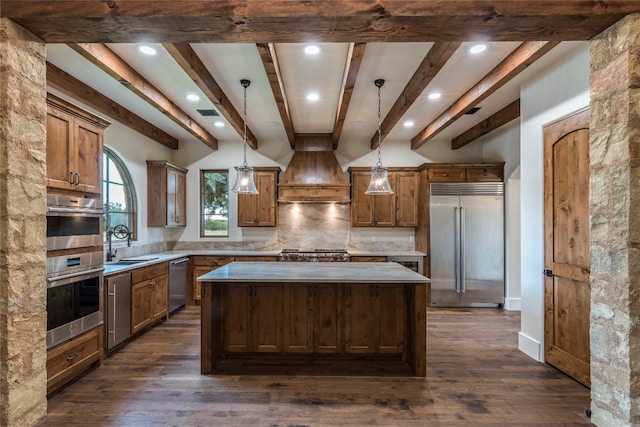 kitchen with pendant lighting, stainless steel appliances, a center island, and dark hardwood / wood-style floors