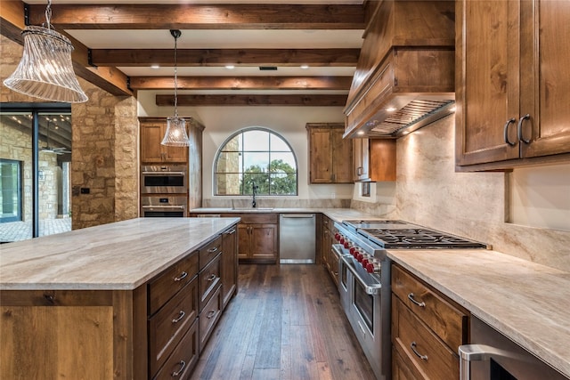 kitchen with decorative light fixtures, custom range hood, appliances with stainless steel finishes, dark wood-type flooring, and a center island