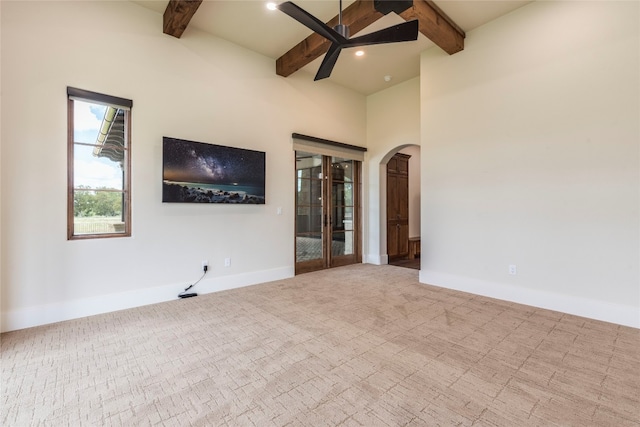 carpeted spare room featuring beamed ceiling and ceiling fan