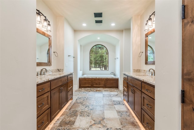 bathroom with vanity and a washtub