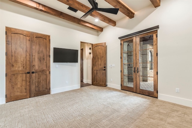 unfurnished bedroom featuring light colored carpet, ceiling fan, and beamed ceiling