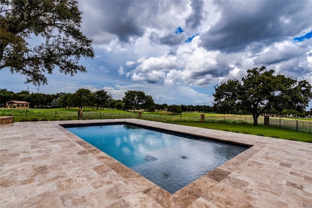 view of swimming pool featuring a lawn and a patio